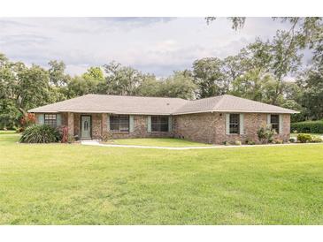 Charming single story brick home with a well-manicured lawn, complimented by lush trees and greenery at 2331 D R Bryant Rd, Lakeland, FL 33810