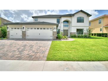 Beautiful two-story home featuring a three-car garage, brick driveway and pristine landscaping at 4312 Juliana Lake Dr, Auburndale, FL 33823
