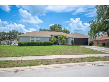 Charming single-story home with a well-maintained lawn and attached two-car garage at 6789 Ashbury Dr, Lakeland, FL 33809