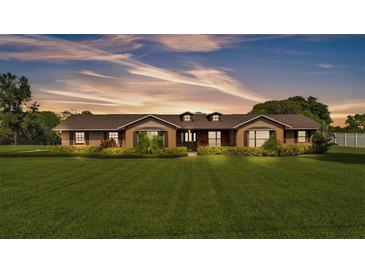 Charming single-story brick home featuring a manicured lawn and well-maintained landscaping at 118 Caloosa Dr, Babson Park, FL 33827