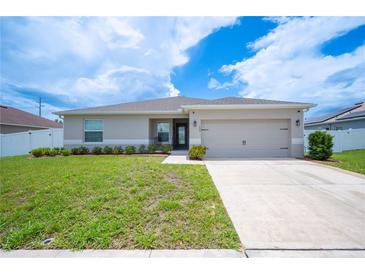 Charming single-story home with manicured lawn and two-car garage at 133 Cloverbrook Trl, Davenport, FL 33837