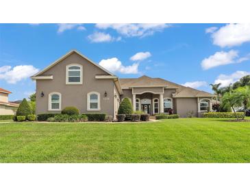 Charming single-Gathering home featuring a well-manicured lawn and beautiful landscaping at 3121 Highlands By The Lake Way, Lakeland, FL 33812