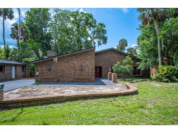 Charming brick home featuring a landscaped yard, mature trees, and a brick mailbox at 6281 Halabrin Rd, Haines City, FL 33844