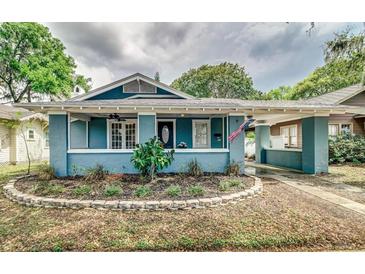 Charming home featuring a covered porch, manicured landscaping, and a driveway at 838 S Tennessee Ave, Lakeland, FL 33801