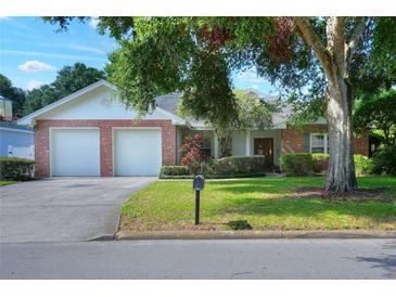 Charming single-story home featuring a brick facade, well-maintained lawn and mature landscaping at 1145 Denton St, Lakeland, FL 33803