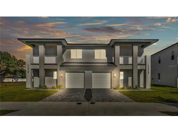 Elegant two-story duplex with a paver driveway, private balconies, and exterior lighting at 1172 Windjammer Dr, Lakeland, FL 33803