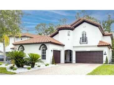 Charming two-story home featuring a terracotta roof, beautiful landscaping, and a three-car garage at 11761 Bella Milano Ct, Windermere, FL 34786