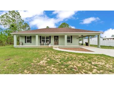 Charming single-story home featuring a welcoming front porch and covered carport at 13522 Rockridge Rd, Lakeland, FL 33809
