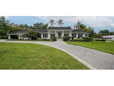Charming single story home featuring a beautifully landscaped lawn and a circular driveway at 1425 Hallam Dr, Lakeland, FL 33813