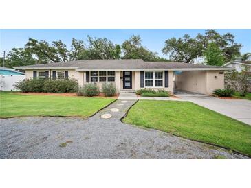 Charming single-story home featuring a well-maintained front yard with a stone walkway and lush landscaping at 2110 Bristol Ave, Lakeland, FL 33803