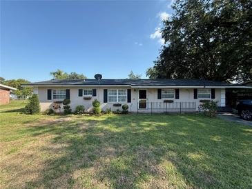 Charming single-story home featuring a well-manicured lawn, mature trees, and a welcoming front entrance at 2424 Bates Sw Ave, Winter Haven, FL 33880
