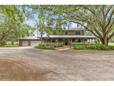 Charming two-story home with a wraparound porch, lush landscaping and detached three car garage at 2911 Walker Rd, Lakeland, FL 33810