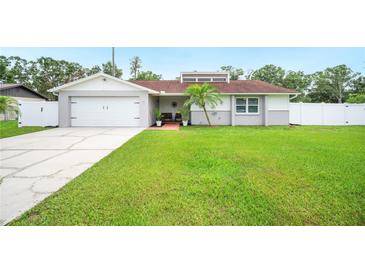 Charming single-story home with a well-manicured lawn and an attached two-car garage at 3080 Cross Fox Dr, Mulberry, FL 33860