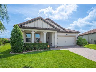 Charming single-story home featuring a well-manicured lawn and a stylish facade with a two car garage and tiled roof at 4124 Prima Lago Cir, Lakeland, FL 33810