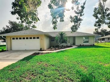 Charming single-story home featuring a well-manicured lawn, two car garage, and a welcoming walkway at 709 N Polk Ave, Fort Meade, FL 33841