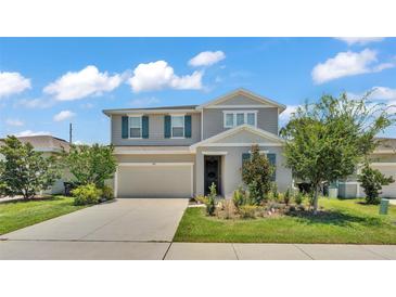 Charming two-story home with well-manicured lawn and gray wood facade at 1125 Mattie Pointe Blvd, Auburndale, FL 33823
