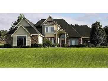 Attractive two-story home featuring stone accents and manicured lawn at 12740 Amber Ave, Clermont, FL 34711