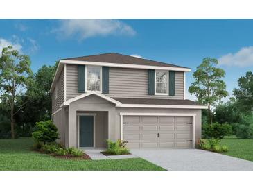 Two-story home featuring gray siding, green shutters, manicured lawn, and an attached two-car garage at 2234 Oldham Ct, Haines City, FL 33844