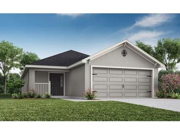 Charming single-story home with a well-manicured lawn, two-car garage, and inviting front porch at 2315 Northumberland Ct, Haines City, FL 33844