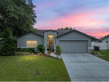 Charming one story home with a well maintained lawn and mature tree in front at 257 Padgett N Pl, Lakeland, FL 33809