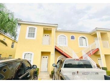 Inviting yellow condo featuring convenient stair access and well-maintained landscaping at 4102 Lake Marion Golf Resort # 4102, Kissimmee, FL 34759