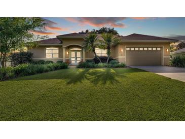 Beautiful home featuring mature landscaping, a well-manicured lawn and a two-car garage at 633 Hart Lake Dr, Winter Haven, FL 33884