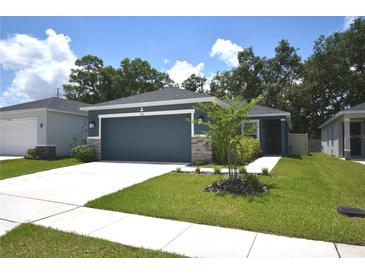 Charming single-story home with a well-maintained lawn and attached two car garage at 312 Walnut Ln, Auburndale, FL 33823
