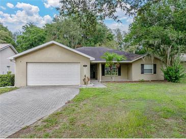 Charming single-Gathering home featuring a two-car garage, a well-maintained lawn, and mature trees at 5522 1St Se St, Lakeland, FL 33812