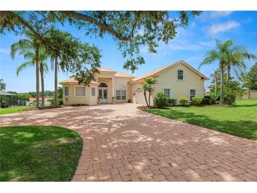Beautiful single-Gathering home with a circular driveway, palm trees, and lush green lawn at 6217 Ashley Dr, Lakeland, FL 33813