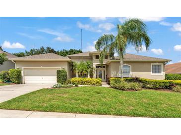 Charming home with lush landscaping, mature palm tree, and well-maintained lawn at 6757 High Grove Dr, Lakeland, FL 33813