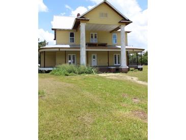 Charming two-story home with metal roof, large columns, and wraparound porch at 701 1St Ne St, Fort Meade, FL 33841