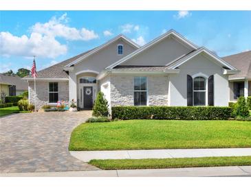 Beautiful single-story home with stone accents, manicured lawn, and a brick-paved driveway in a desirable community at 7770 Lake James Blvd, Lakeland, FL 33810