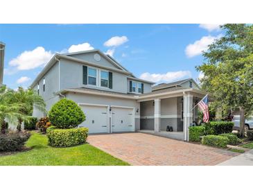 Charming two-story home with a manicured lawn, brick-paved driveway, and a two-car garage at 8120 Soldierwood St, Winter Garden, FL 34787