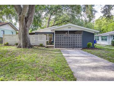 Charming single-story home with a modern exterior design, mature trees, and inviting curb appeal at 906 E Lowell St, Lakeland, FL 33805