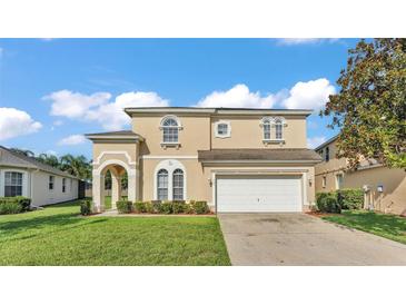 Charming two-story home with a well-manicured lawn and a two car garage at 141 Minniehaha Cir, Haines City, FL 33844