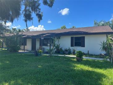 Charming single-story home with a front yard and some landscaping on a sunny day at 2250 Maple Hill Dr, Lakeland, FL 33811