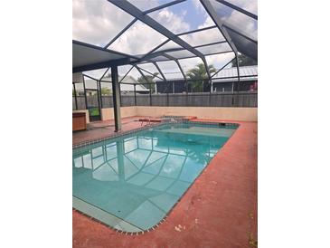 Covered backyard pool with patio, fence, and ladder for summer enjoyment at 341 Sterling Dr, Winter Haven, FL 33884