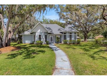 Charming single-story home featuring a turret, inviting entryway, and mature landscaping at 5722 Antler Trl, Lakeland, FL 33811