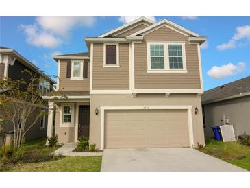 Two-story home featuring a two-car garage, neutral siding, and a well-maintained front lawn at 6524 Great Bear Drive Blvd, Lakeland, FL 33805
