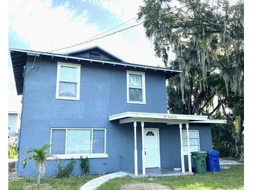 Two-story home featuring a front porch, a well-maintained yard, and a large tree at 121 F Sw Ave, Winter Haven, FL 33880