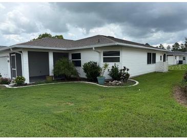 Charming home featuring a well-manicured lawn and a screened-in lanai for outdoor relaxation at 2235 Grand Cypress Dr # 561, Lakeland, FL 33810