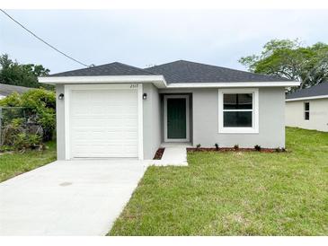 Charming single-story home featuring a one-car garage, green front door, and fresh landscaping at 2517 Sunset Dr, Winter Haven, FL 33881