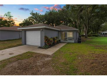 Charming single-story home with a one-car garage and a well-maintained front yard at sunset at 3015 Thornhill Rd, Winter Haven, FL 33880