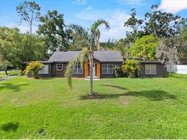 Charming single-story home boasts a large front yard, mature landscaping, and freshly painted facade at 504 Prado Pl, Lakeland, FL 33803