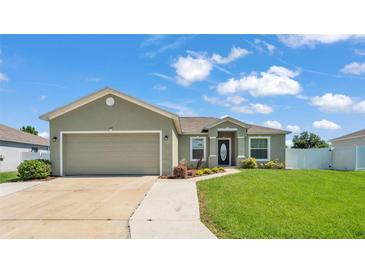 Charming single-story home with a well-manicured lawn, inviting entryway, and a spacious two-car garage at 577 Majestic Gardens Blvd, Winter Haven, FL 33880