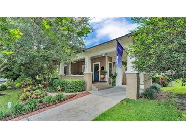 Charming home showcasing a lovely landscaped front yard, covered porch, and inviting blue front door at 608 Finney St, Lakeland, FL 33803
