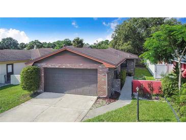 Charming home featuring a brick facade, well-maintained landscaping, and a two-car garage at 1523 Mariner Rd, Lakeland, FL 33803