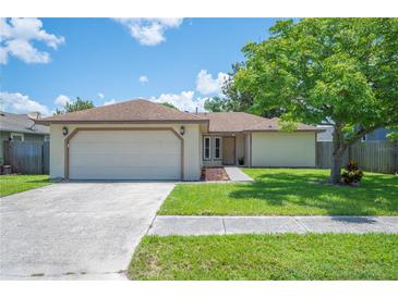 Charming single-story home with a well-manicured lawn, mature tree, and an attached two-car garage at 1081 Sunshine Sw Way, Winter Haven, FL 33880