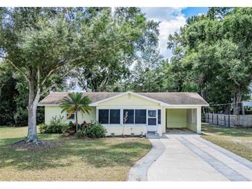 Charming single-story home featuring a landscaped front yard and driveway with a carport at 132 Kinstle Ave, Auburndale, FL 33823