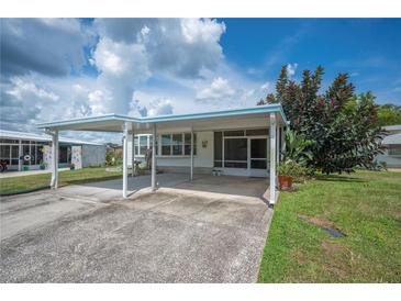 Charming home exterior featuring a covered carport and well-maintained lawn at 1610 Reynolds Rd # 214, Lakeland, FL 33801